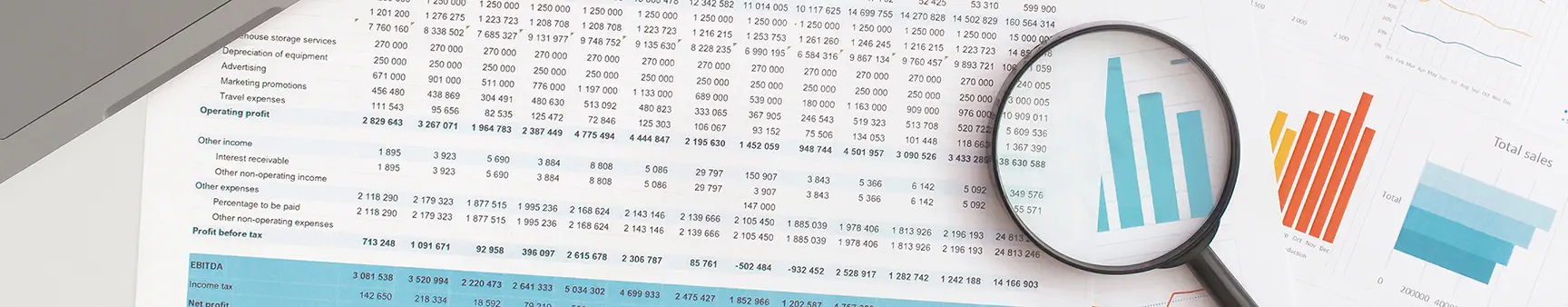 Financial documents and charts under a magnifying glass, illustrating Mezzo Financial’s bookkeeping and financial analysis services for Central Ohio clients in Delaware, Marion, Mansfield, Mount Vernon, and Cardington, as well as nationwide businesses